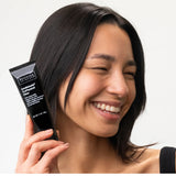 Model showcasing Intellishade® TruPhysical Clear 1.7 oz moisturizer, perfect for enhancing natural radiance.
