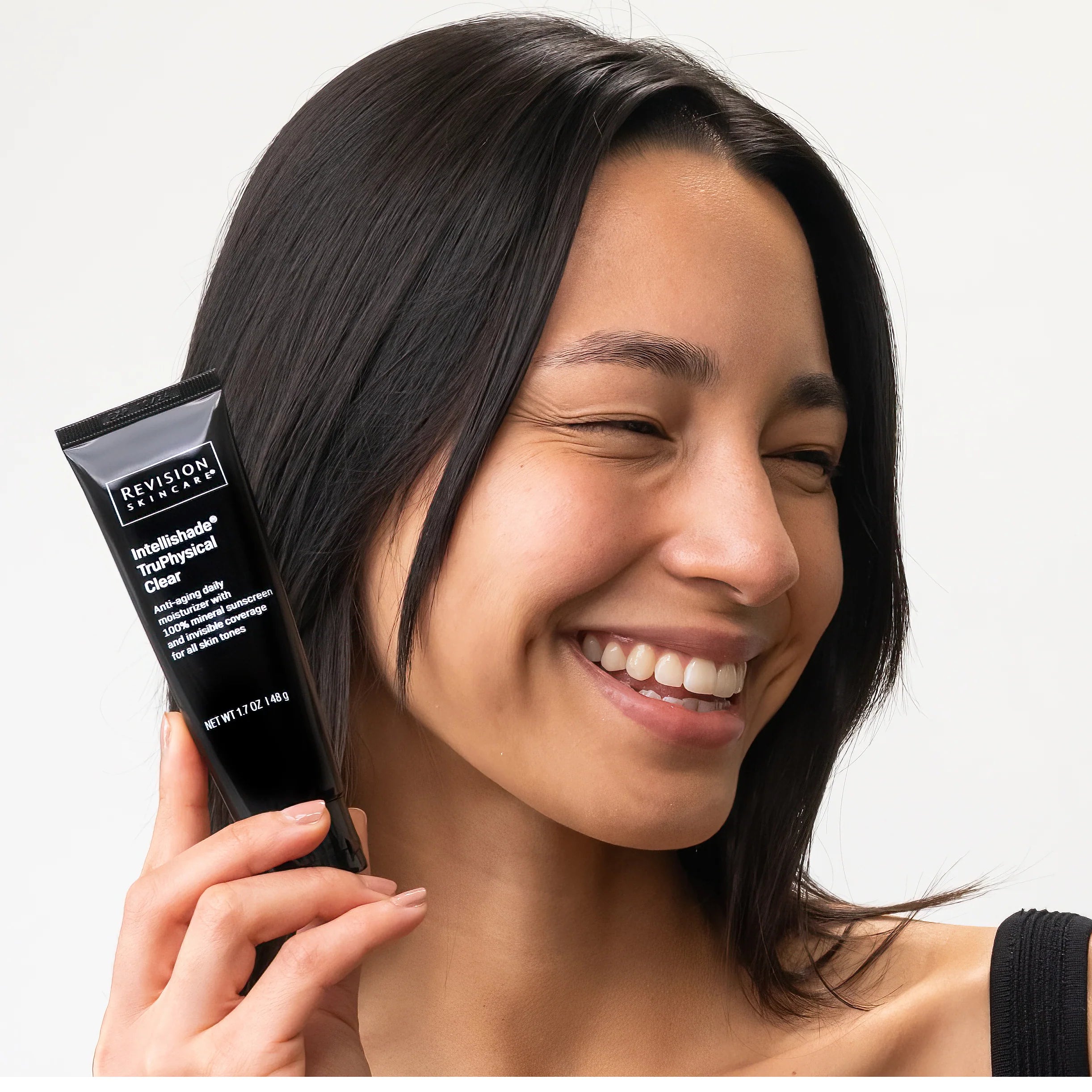 Model showcasing Intellishade® TruPhysical Clear 1.7 oz moisturizer, perfect for enhancing natural radiance.
