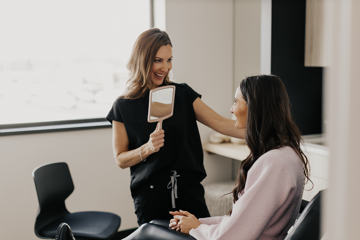 Client consultation at MK Aesthetics Med Spa in Minnetonka, showcasing a joyful moment with a mirror.