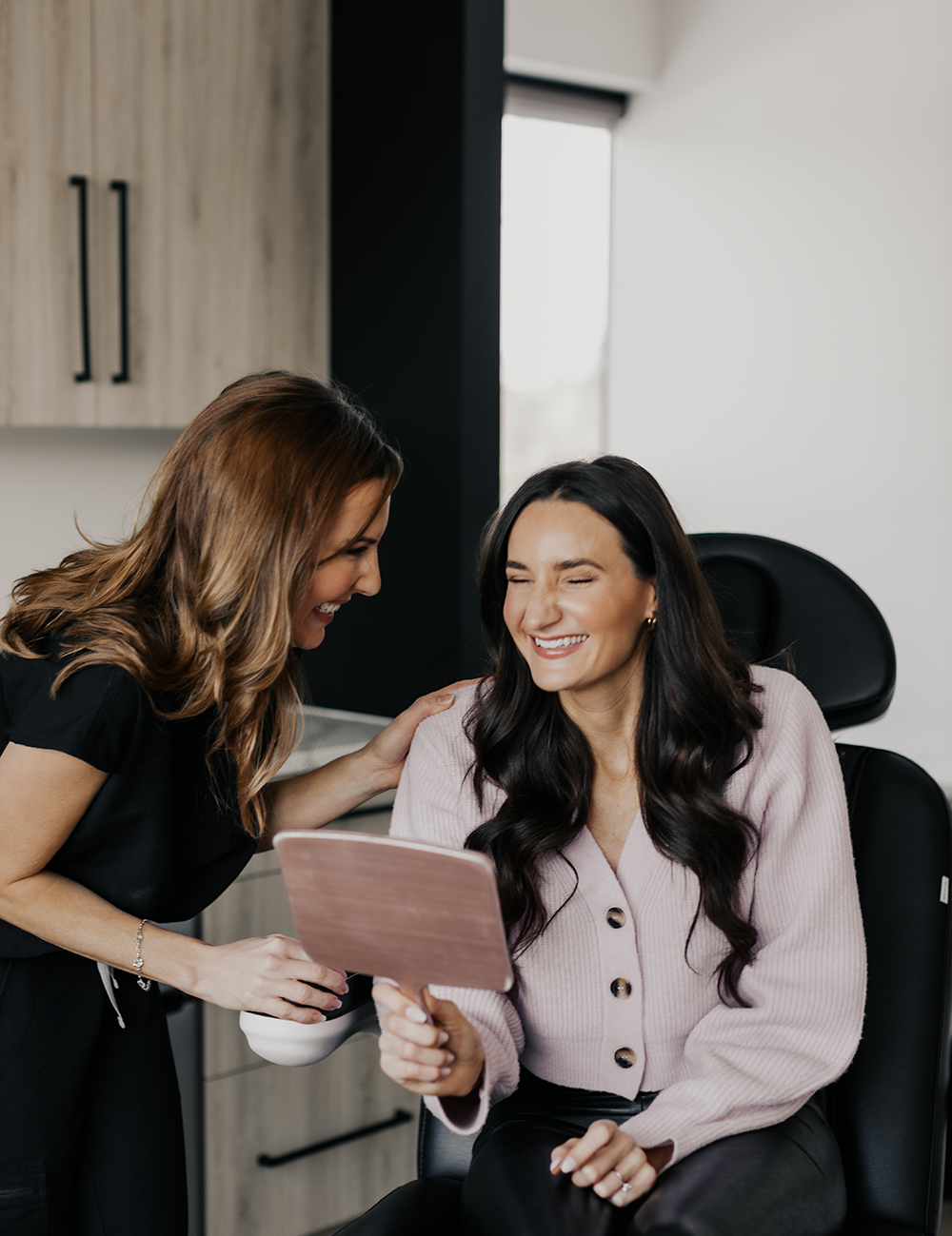 Client consulting with a practitioner at MK Aesthetics Minnetonka Med Spa, smiling and reviewing results.