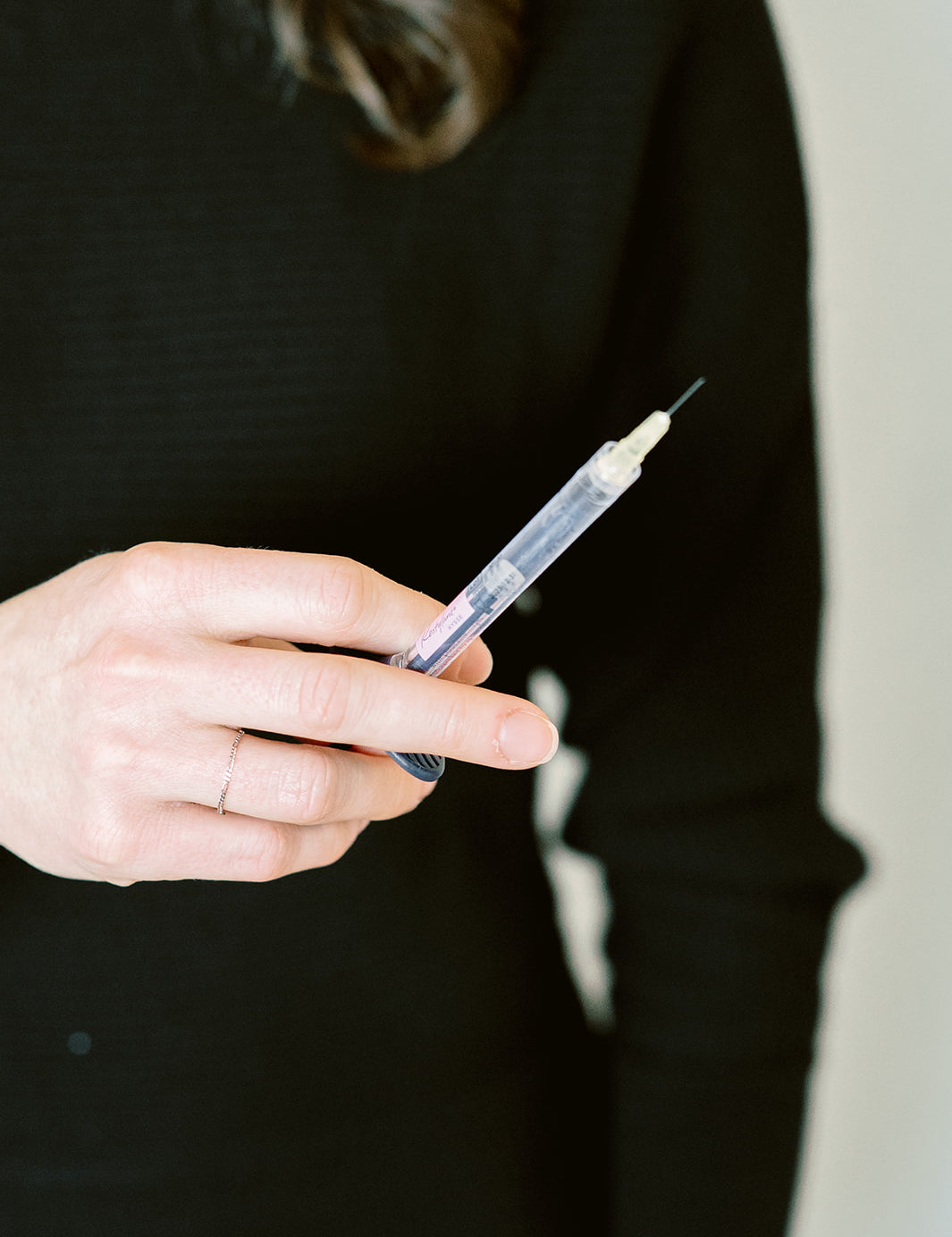 Hand holding a syringe for aesthetic treatments at MK Aesthetics in Minnetonka Med Spa.