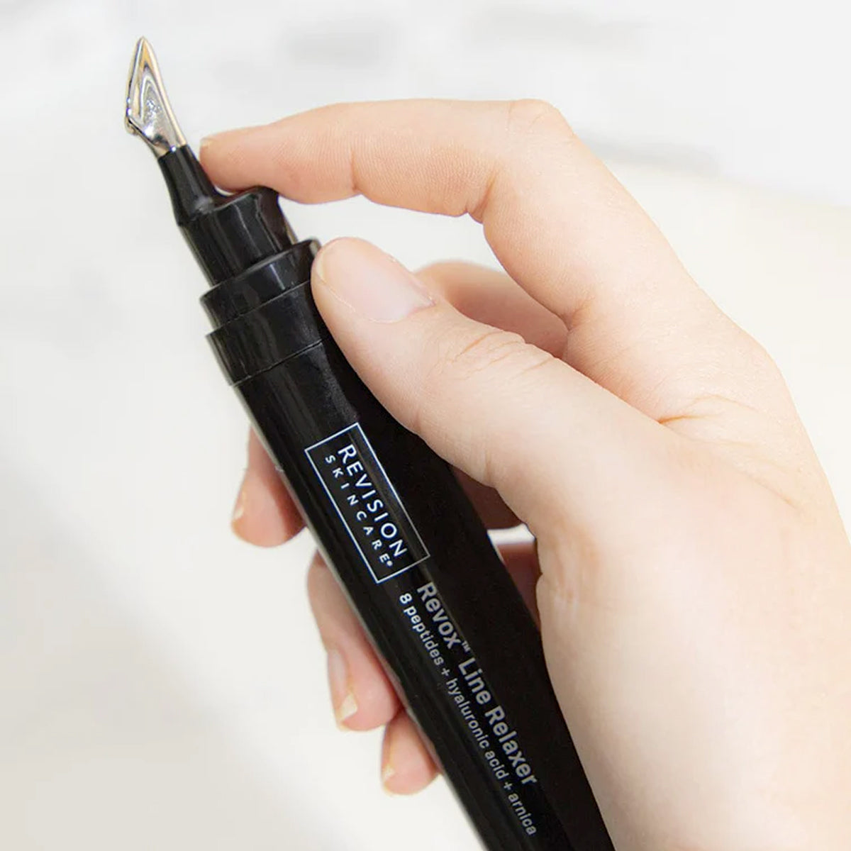 Close-up of Revox™ Line Relaxer 1 fl oz serum applicator for targeted wrinkle treatment.