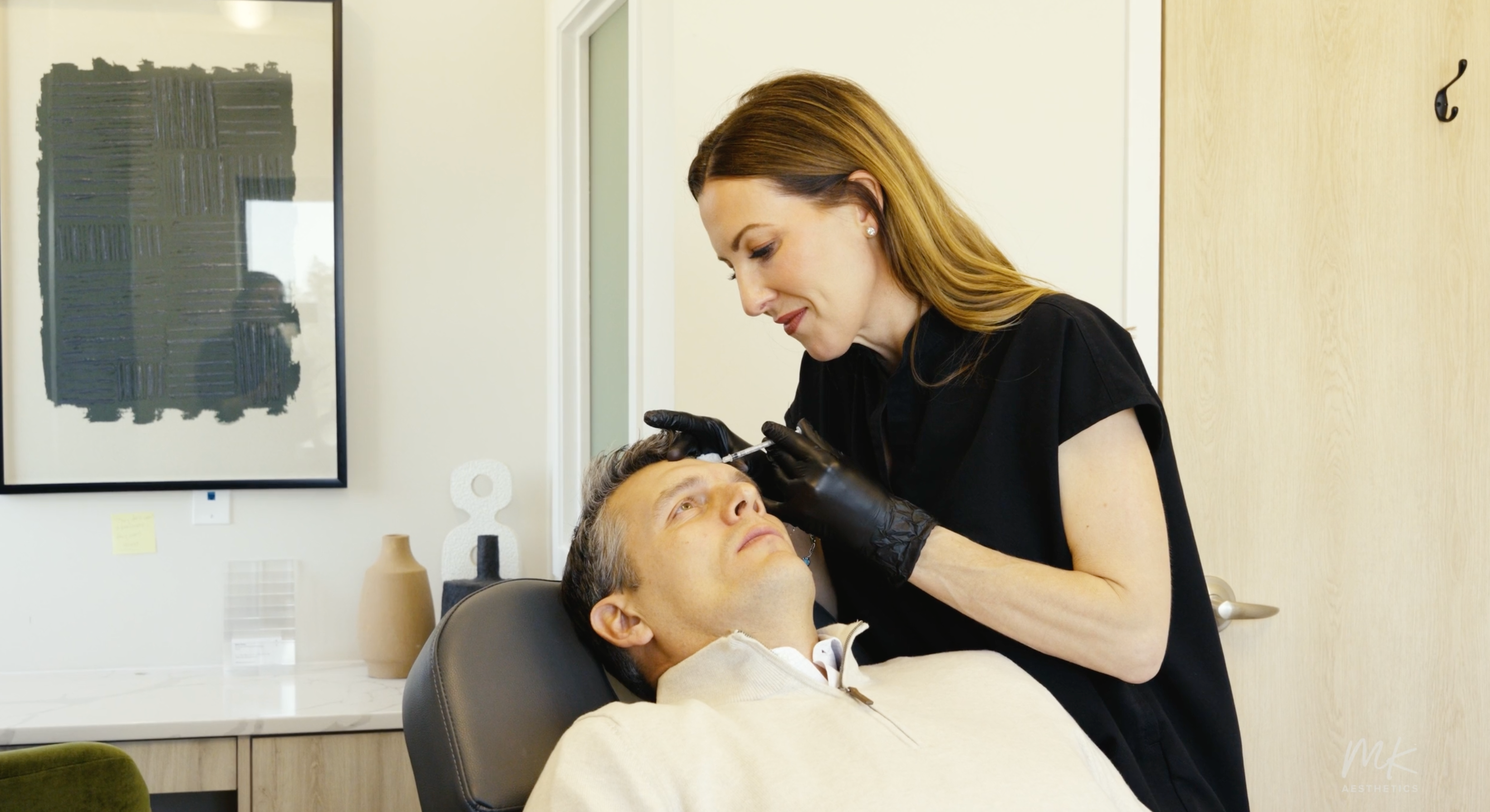 MK Aesthetics Med Spa in Minnetonka: professional treatment session with a client in a modern setting.