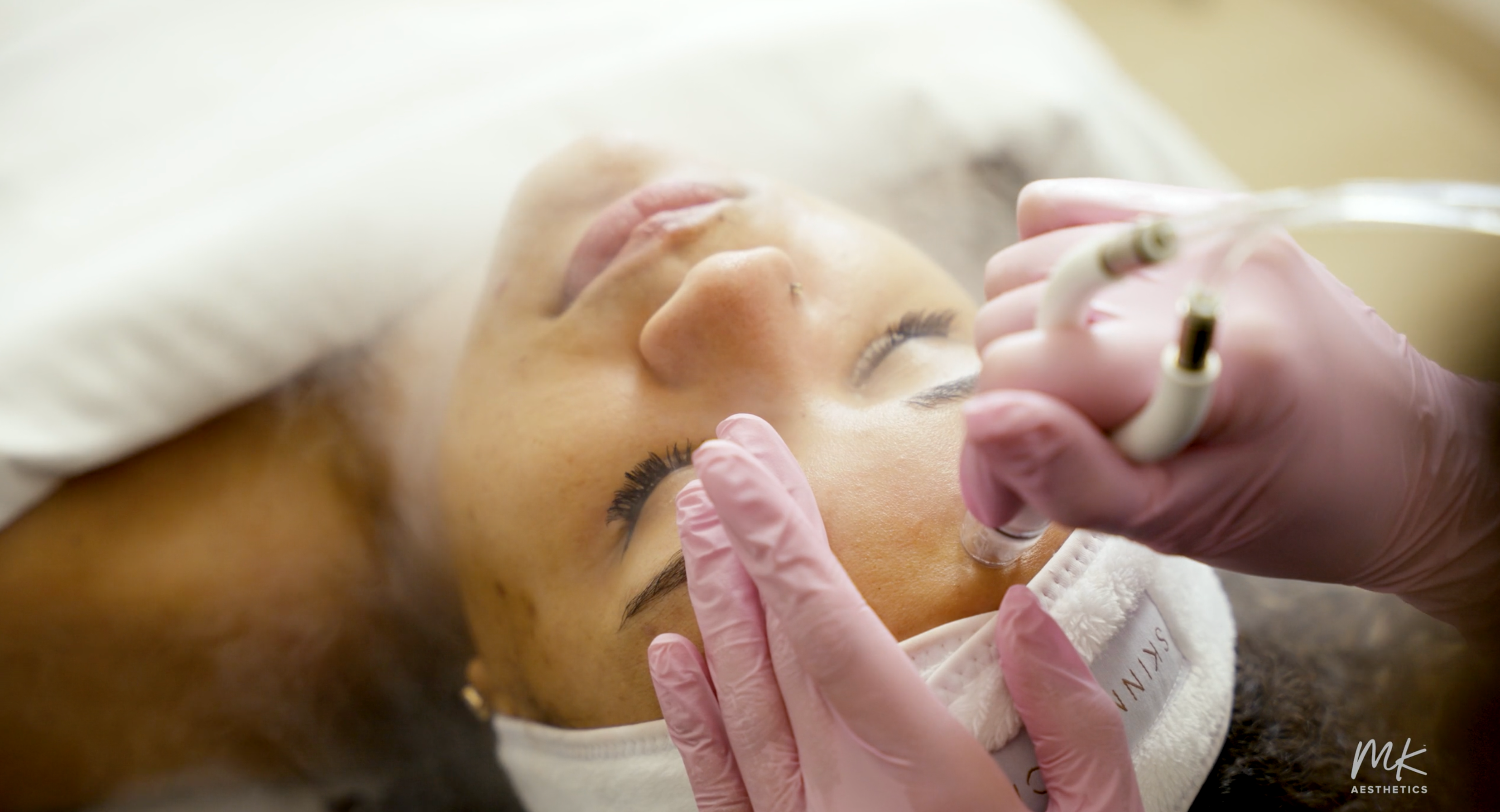 A client receiving a skincare treatment at MK Aesthetics in Minnetonka, showcasing a relaxing med spa experience.