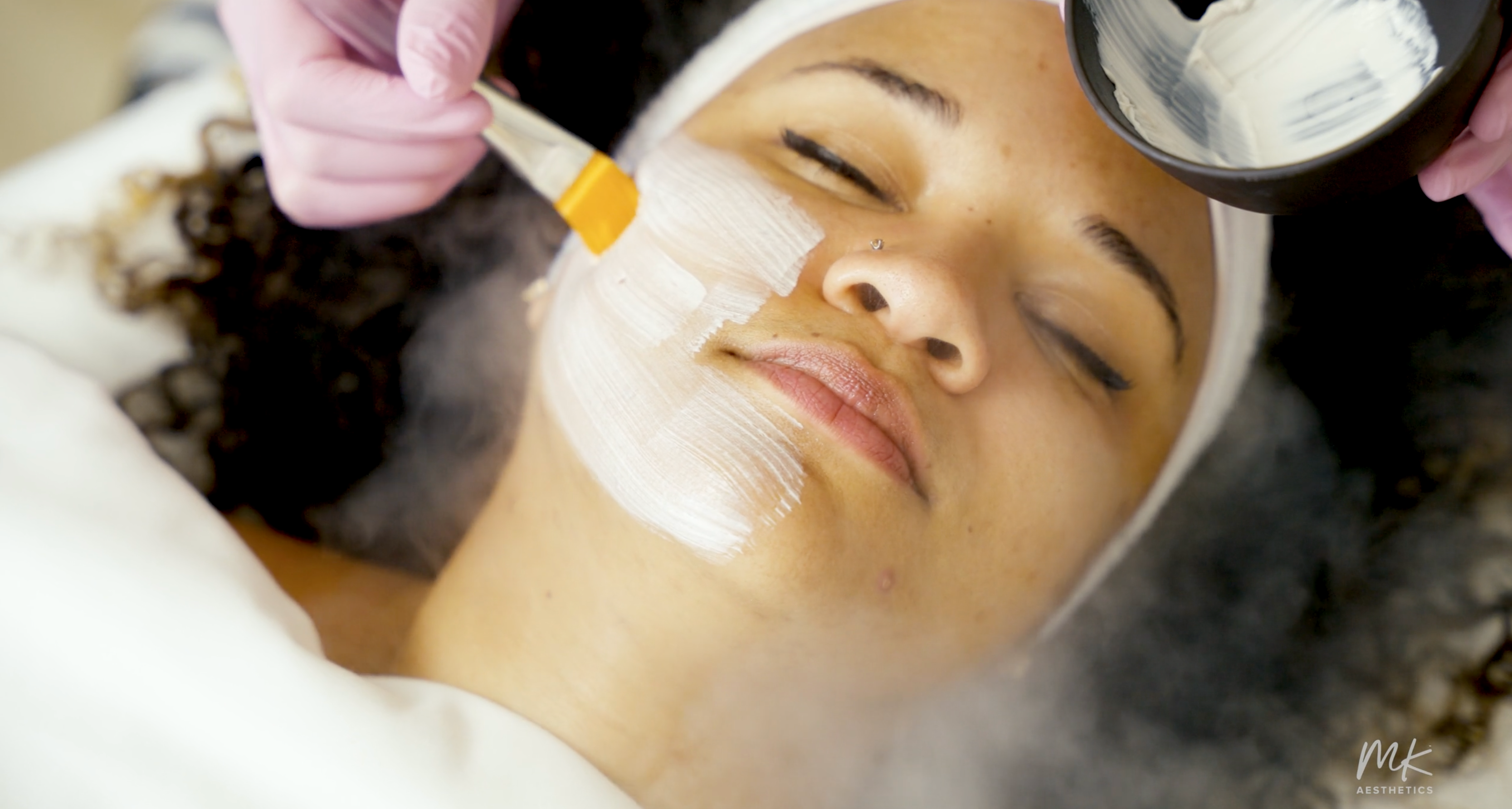 Client receiving a facial treatment at MK Aesthetics Minnetonka, showcasing med spa services and skincare expertise.