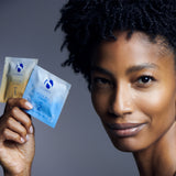 A woman holding two packets of Active Peel System by MK Aesthetics, showcasing a smooth, youthful complexion.