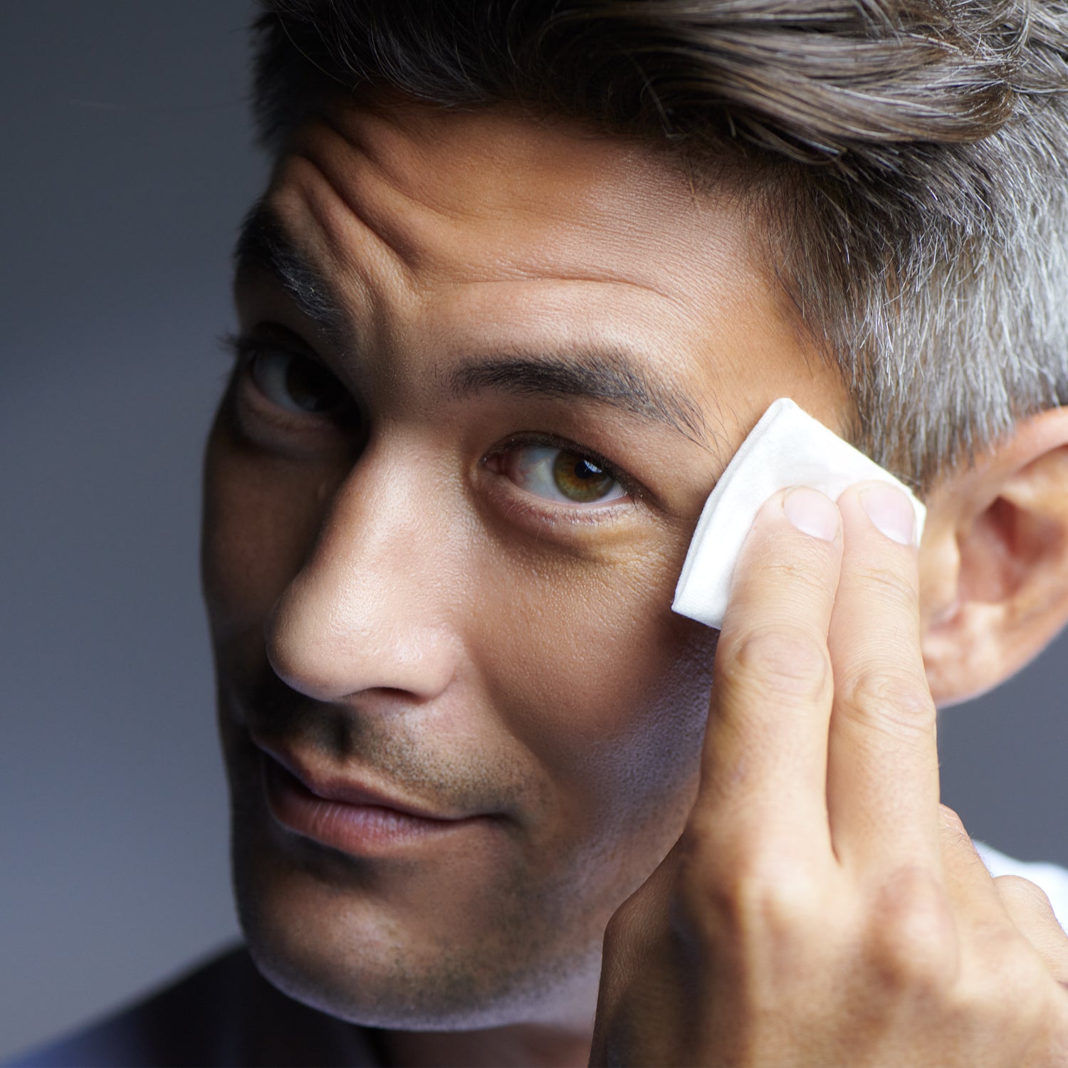 Man applying Active Peel System treatment to his face for skin rejuvenation and hydration.