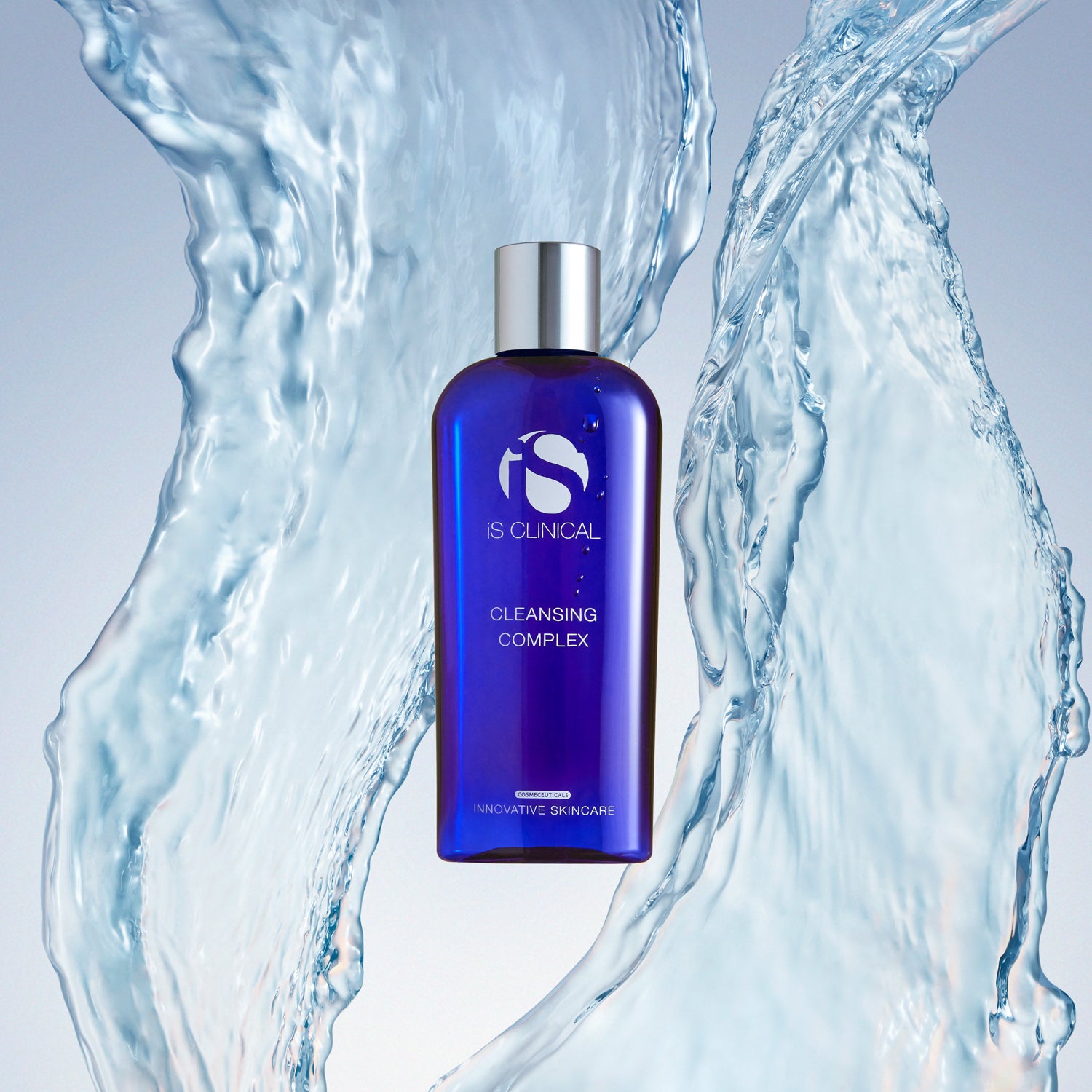Cleansing Complex by iS Clinical in blue bottle surrounded by water, ideal for all skin types and ages.