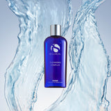 Cleansing Complex by iS Clinical in blue bottle surrounded by water, ideal for all skin types and ages.