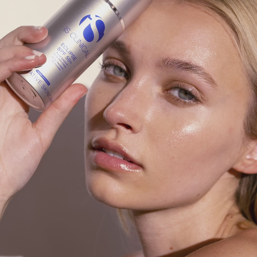 Model holding Eclipse SPF 50+ sunscreen, showcasing radiant skin and highlighting MK Aesthetics at Aesthetics Spa.
