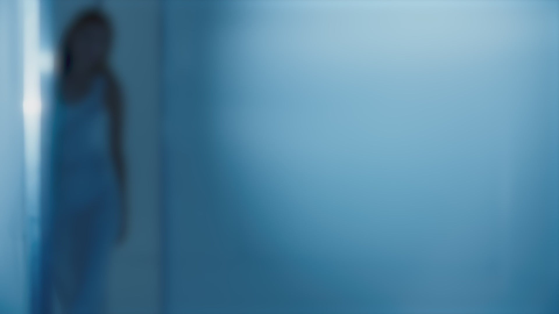Image of a figure in soft focus against a blue background, representing tranquility and calmness.