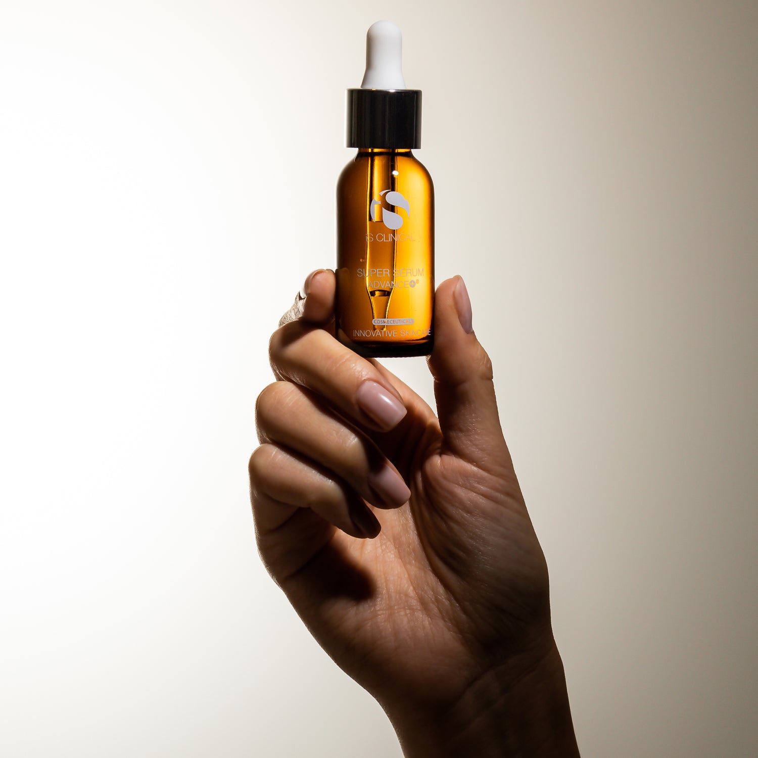 Hand holding Super Serum Advance+ bottle from MK Aesthetics, showcasing advanced anti-aging skincare.