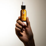 Hand holding Super Serum Advance+ bottle from MK Aesthetics, showcasing advanced anti-aging skincare.