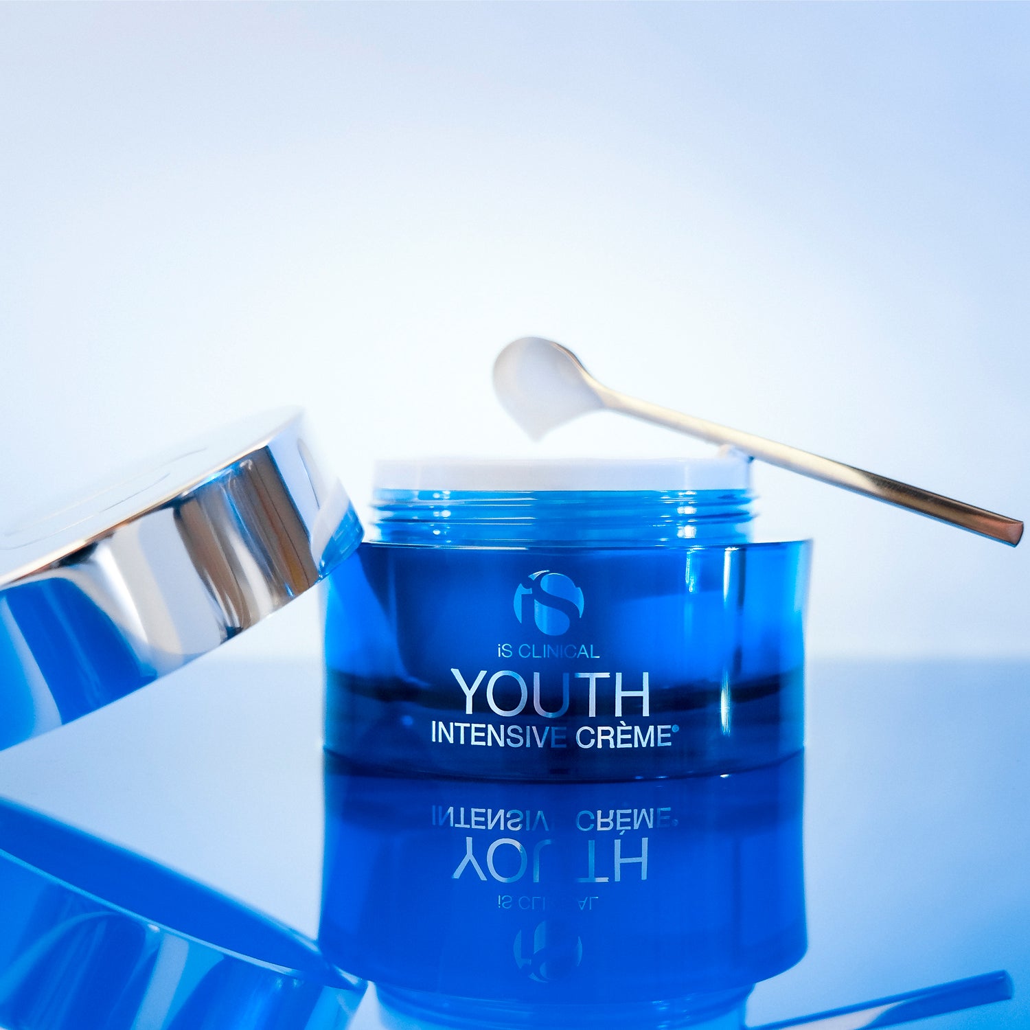 Youth Intensive Crème 1.7oz in a blue jar with a silver lid and spoon, showcasing luxurious skincare.